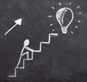 A drawing shows a person climbing some stairs to reach their goal 